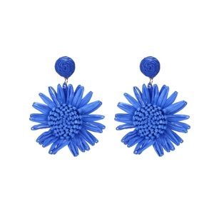 Vue détaillée des boucles d'oreilles tournesol en raphia bleu avec textures tissées
