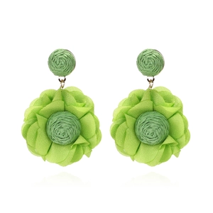 Detailed view of handmade lime green chiffon flower earrings with raffia woven centers