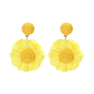 Close-up of bright yellow chiffon flower earrings with handcrafted raffia woven tops