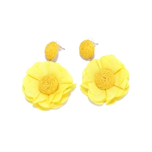 Detailed view of handmade raffia and yellow chiffon floral drop earrings with woven beads