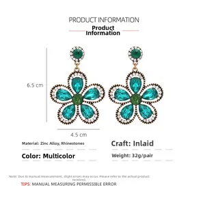 Detail view of floral drop earrings with green rhinestones and size specifications