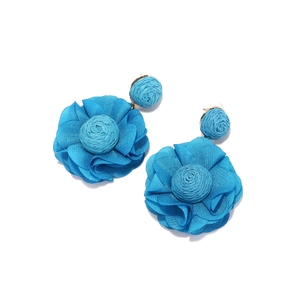 Close-up of bright blue handmade woven raffia and chiffon flower earrings with beads