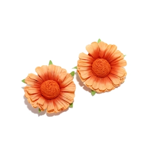 Macro shot of orange handmade fabric flower earrings with realistic petal texture and leaf detail