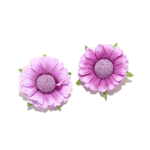 Macro detail of purple fabric daisy earrings with realistic petals and green leaves