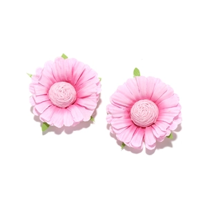 Macro detail of handmade pink fabric daisy earrings with realistic petal texture