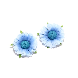 Detailed close-up of handmade fabric daisy earrings with gradient blue petals and green leaves