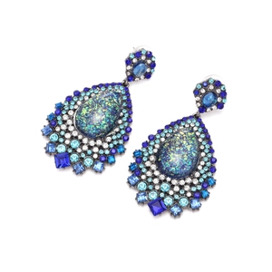 Détail de boucles d'oreilles goutte avec strass bleus et pierres centrales dégradées