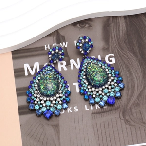 Détail des boucles d'oreilles goutte d'eau avec cristaux bleus et verts au style rétro