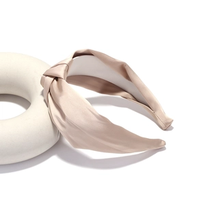Elegant champagne satin knotted headband with a smooth silk finish and luxury texture