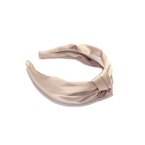 Elegant champagne satin knotted headband with a smooth silky texture and stylish design