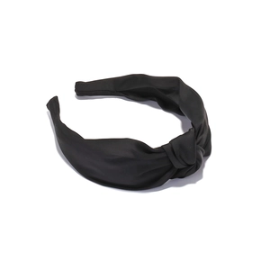 Close-up of a wide black satin knotted headband featuring premium smooth silk texture