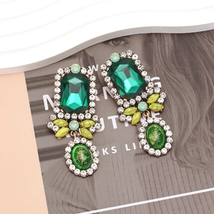 Detailed view of vintage court style emerald crystal earrings with marble leaf accents