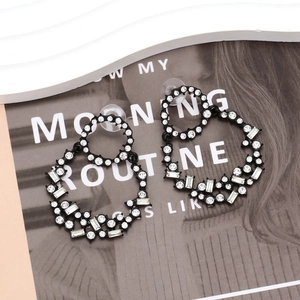 Black alloy geometric hoop earrings with sparkling rhinestones on a fashion magazine