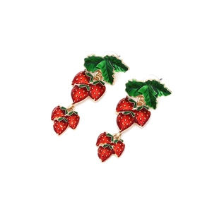 Boucles d'oreilles fraises rouges avec feuilles vertes et alliage doré sur fond blanc