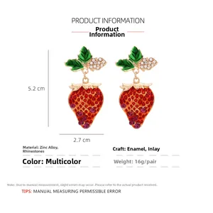Detailed view of strawberry drop earrings featuring green leaves and sparkling rhinestones