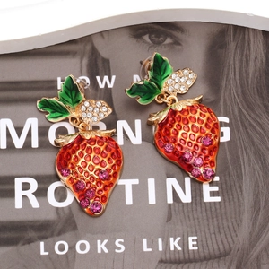 Cute strawberry drop earrings with red enamel leaves and pink rhinestones on fashion magazine