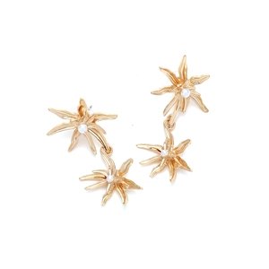 Detailed view of vintage gold flower drop earrings with white pearls in the center