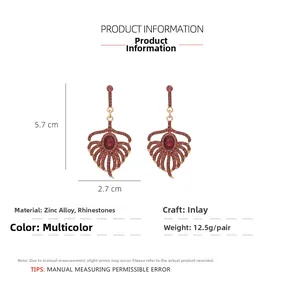 Detail of red rhinestone peacock feather earrings with gold alloy and 5.7cm length