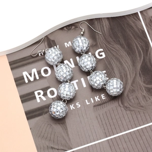 Elegant silver disco ball drop earrings with reflective mirror beads on fashion magazine