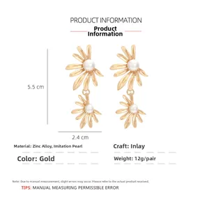 Detail view of golden flower earrings with white imitation pearls and size measurements