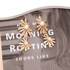 Retro gold-plated daisy flower earrings with faux pearls on fashion magazine cover