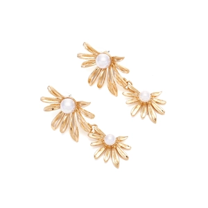 Macro shot of gold daisy drop earrings with pearl center detail and floral petals