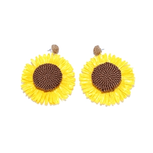Detail of handmade woven raffia sunflower earrings featuring yellow petals and brown center
