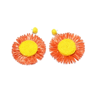 Detailed texture of handcrafted raffia sunflower earrings with vibrant orange petals