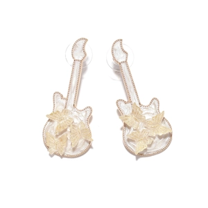 Macro detail of cream enamel guitar stud earrings with golden 3D glitter butterflies