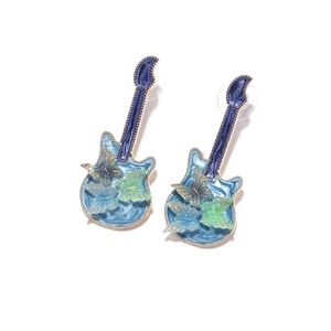 Detail view of blue enamel guitar stud earrings with butterfly motifs and gold plating