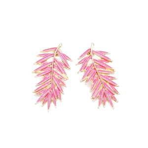Détail de boucles d'oreilles en forme de feuille avec émail rose et métal doré