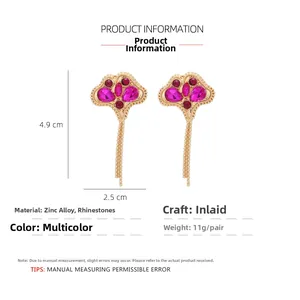 Detailed view of rhinestone leaf tassel earrings in gold and red with size 4.9x2.5cm