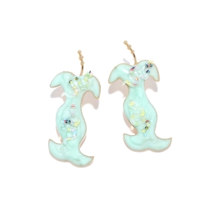 Détail de boucles d'oreilles en résine vert menthe avec paillettes et crochets dorés