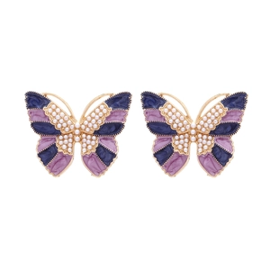 Vintage gold butterfly earrings with purple enamel coating and white pearls on white background