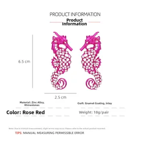 Macro des boucles d'oreilles hippocampe rose rouge montrant l'alliage et les strass