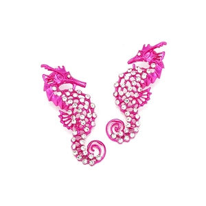 Détail de boucles d'oreilles hippocampe avec finition laquée violette et strass brillants