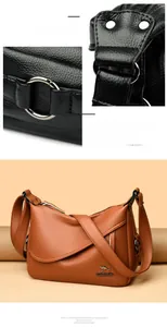 Detail of lychee pattern leather texture and silver metal rings on a crossbody bag