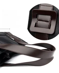 Detail view of premium black cowhide leather texture with fine stitching on tote bag