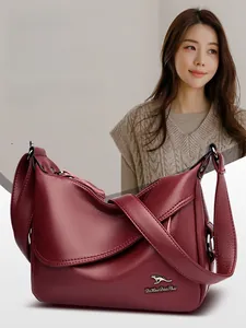 Close-up of burgundy litchi grain leather texture and metallic kangaroo logo on shoulder bag