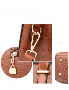 Details einer braunen Handtasche mit Straußenleder-Struktur und goldenen Metallbeschlägen