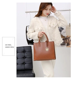 Detail of brown quilted leather handbag with gold leaf charm held by a model