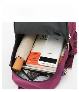 Vue de dessus de l'intérieur spacieux du sac à dos en nylon violet avec livres et parapluie