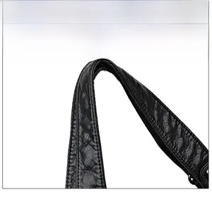 Detail of soft quilted leather handles on a black tote bag showing comfortable grip