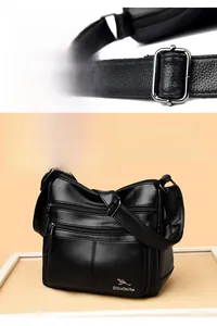 Macro detail of silver kangaroo metal logo and hardware on black leather shoulder bag