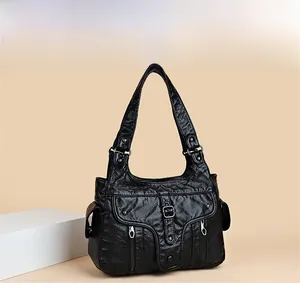 Close-up of black textured leather handbag with multi-pocket design and flap closure detail