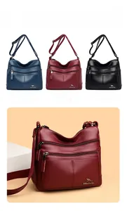 Detail of multi-pocket soft leather crossbody bag with metal logo and layered zippers