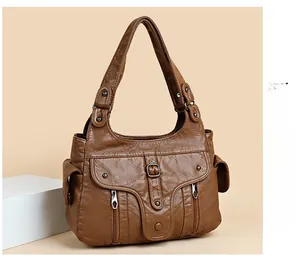 Detail of vintage brown PU leather handbag featuring multi-pockets and soft lychee texture