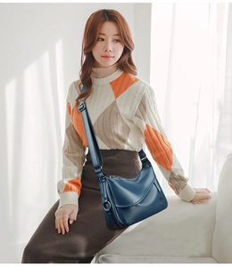 Detail of dark blue litchi pattern leather crossbody bag with golden kangaroo logo