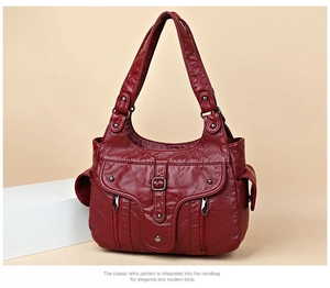 Macro shot of burgundy soft PU leather handbag with vintage pleats and metal zippers
