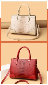 Detailansicht der Kroko-Lederprägung an schicker Handtasche mit goldenen Schnallen